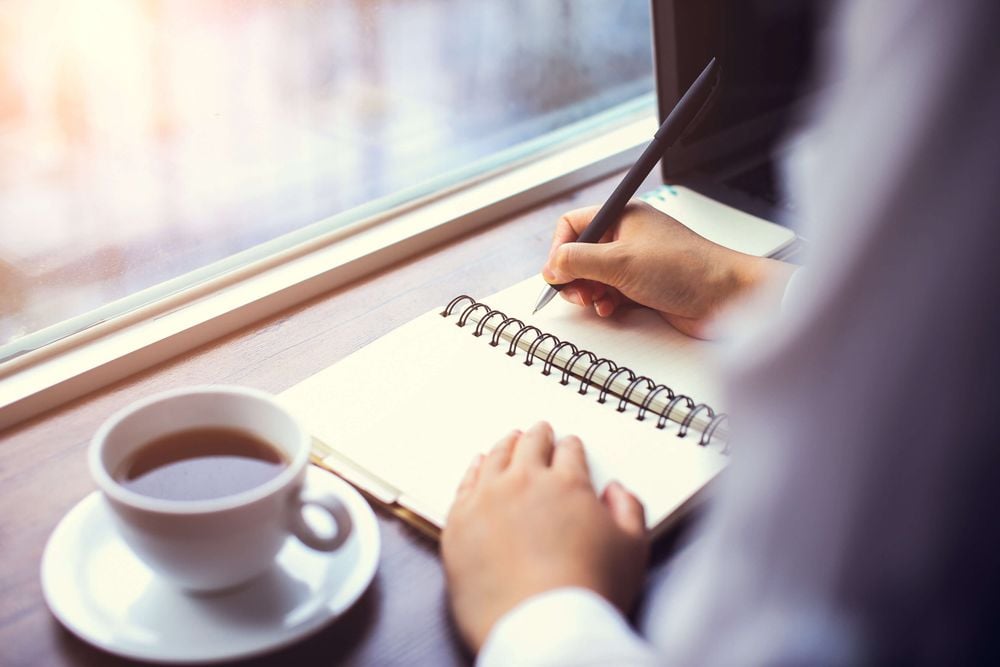 Kaffee und Notizbuch zur Vorbereitung des Mitarbeitergesprächs